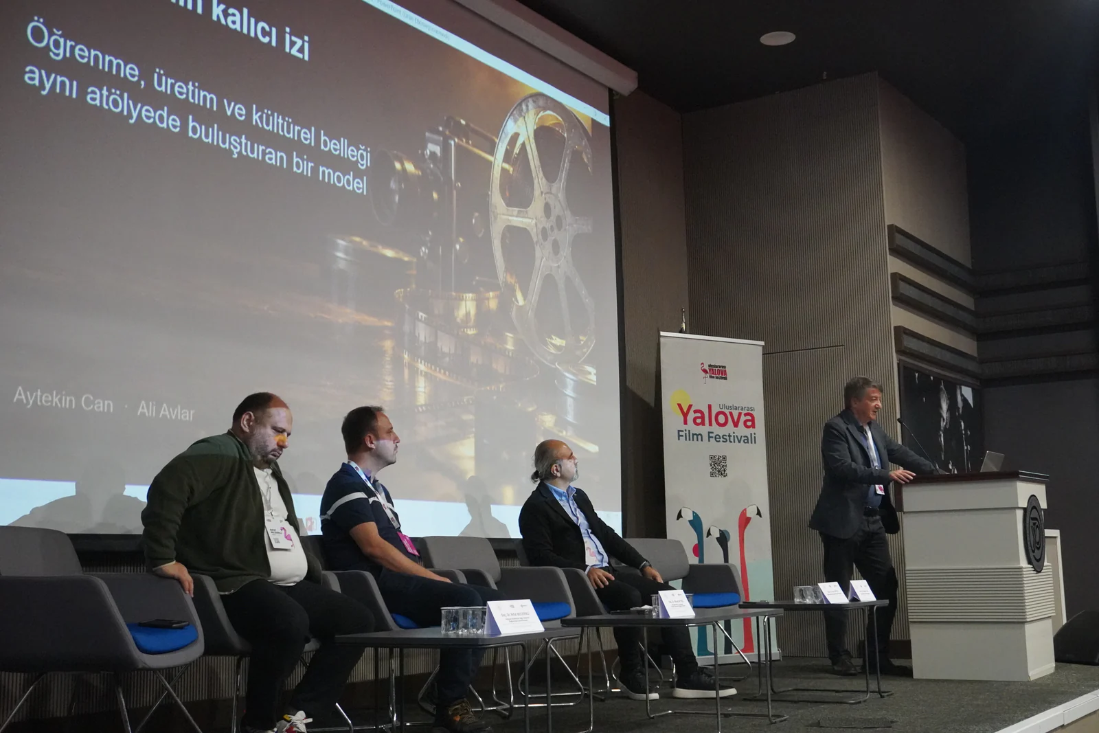 Yalova Film Festivali panelinde konuşmacılar sahnede oturum gerçekleştiriyor.